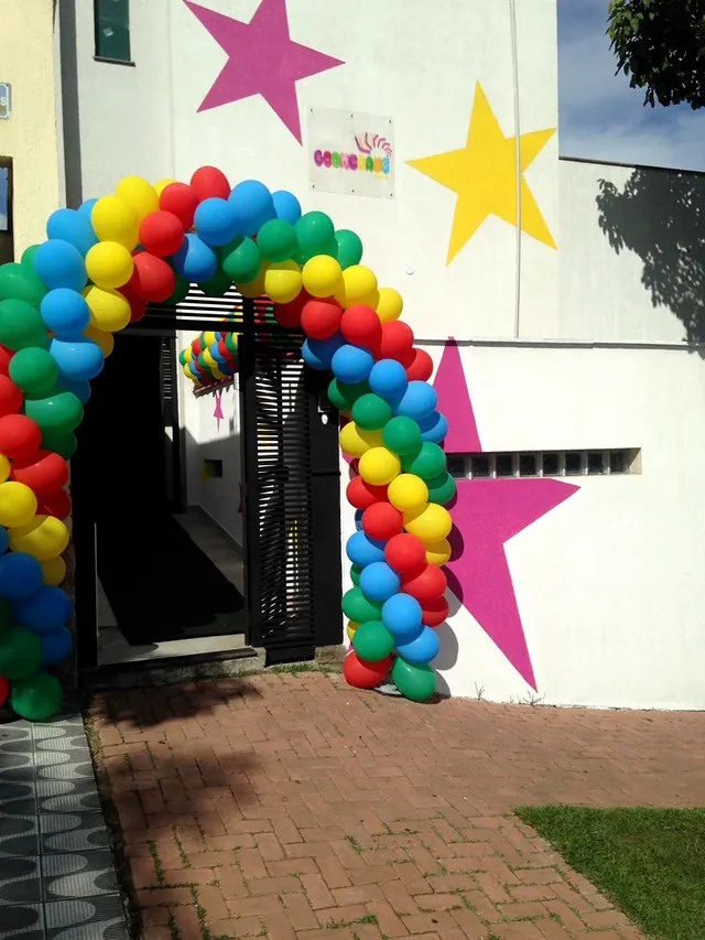 Entrada do Boomerang Festas, com arco de balões coloridos e estrelas pintadas no muro