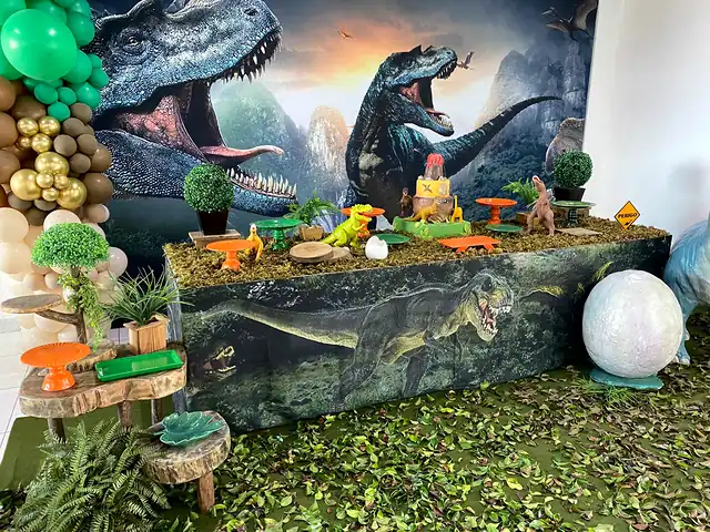 Mesa de festa com tema de dinossauros, painel de floresta e ovo gigante