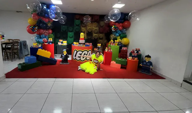 Festa com tema de blocos de montar, com peças gigantes e tapete vermelho